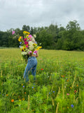 Woman holding a lush wildflower bouquet in a summer field at Madison's Meadow, Clyde, Ohio